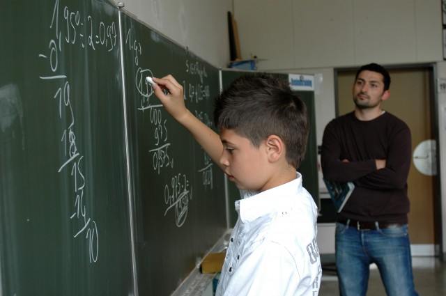 Ein Junge schreibt an einer Schultafel.